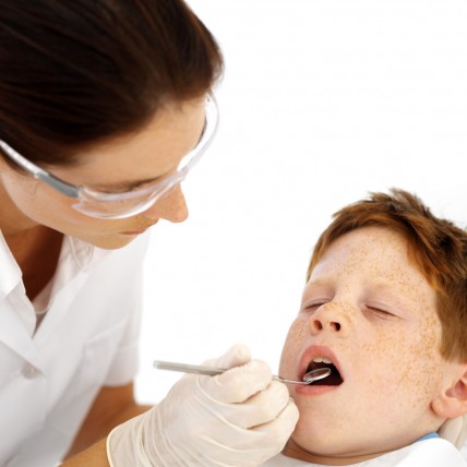 Dentist Examining Little Boys Teeth --- Image by © Royalty-Free/Corbis